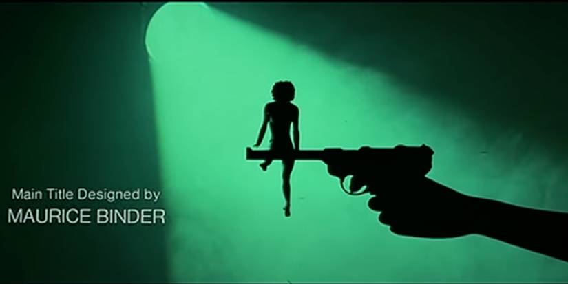 A girl performs gymnastics on the barrel of a gun in a misty, green spotlight. 