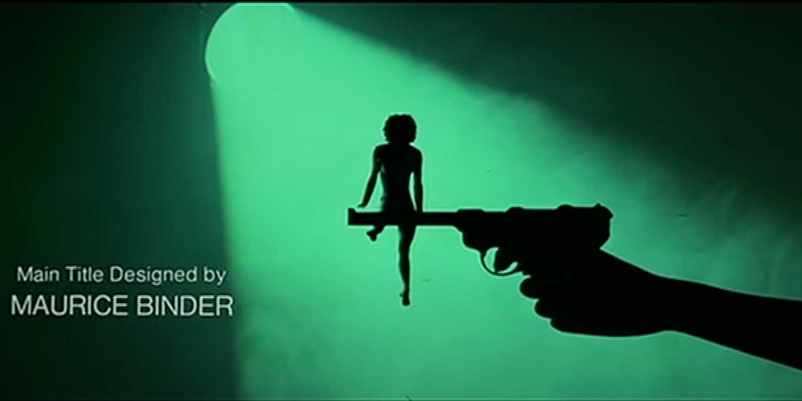 A girl performs gymnastics on the barrel of a gun in a misty, green spotlight.