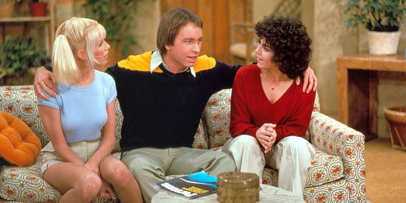 Chrissy (Suzanne Somers), Jack (John Ritter), and Janet (Joyce DeWitt), sit together in Three's Company. 