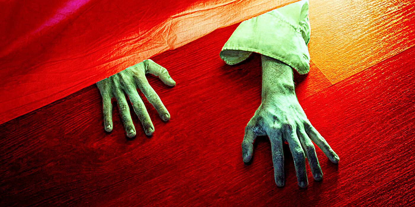 Pair of hands crawling out from under a bed onto floorboards