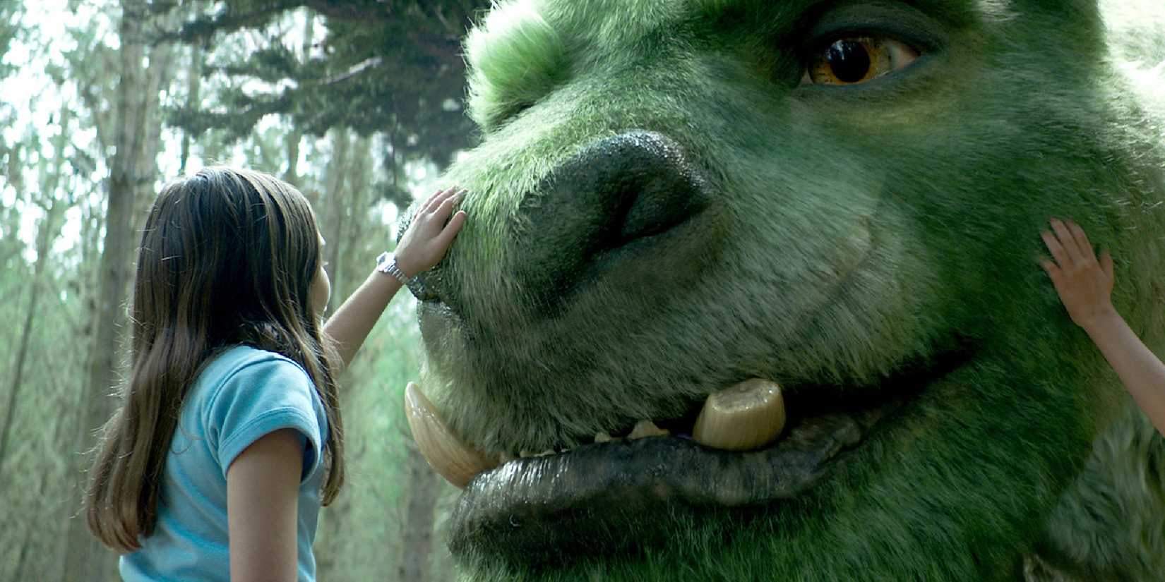 A child petting a CGI dragon in Pete's Dragon.