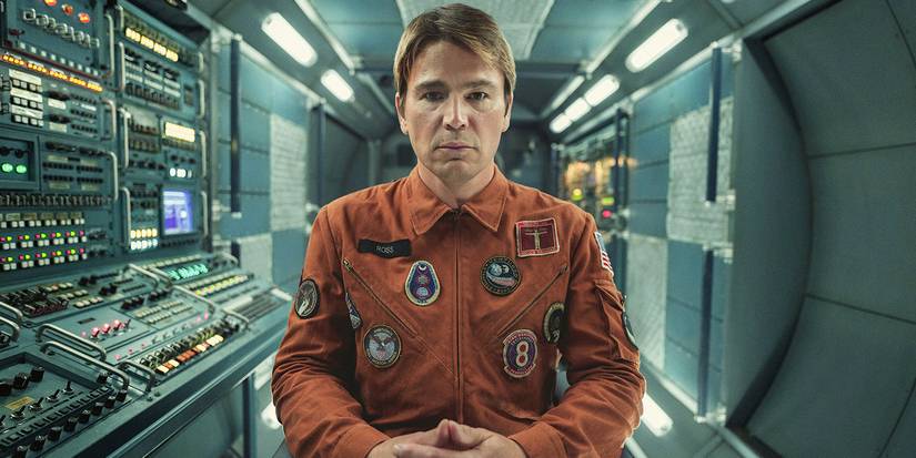 David sitting on the spaceship, staring into space in a scene from Black Mirror, Beyond the Sea