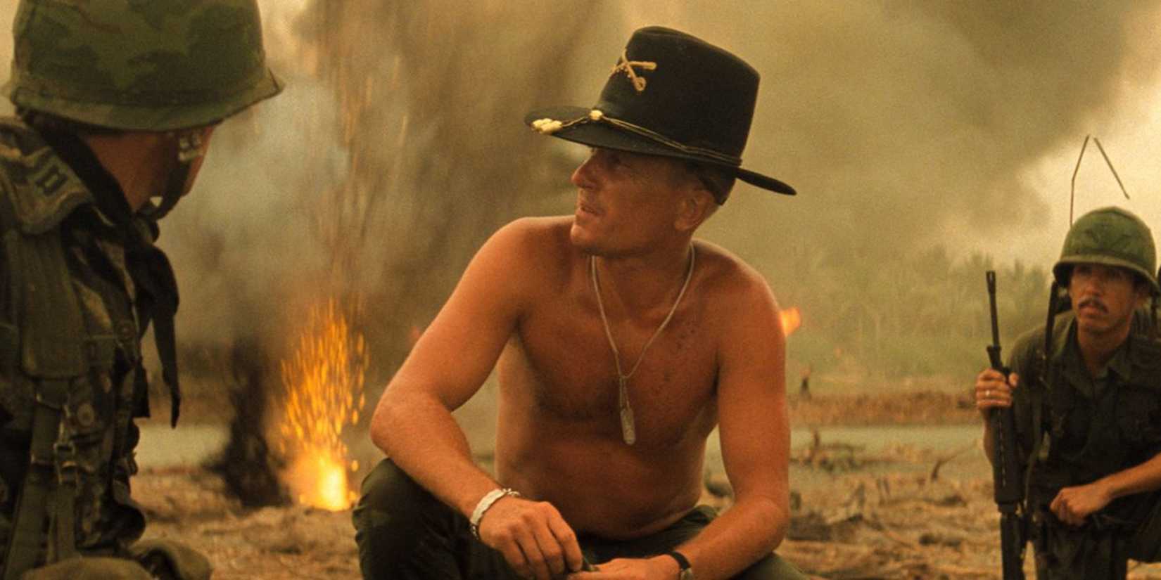 Robert Duvall as Lt. Col. Bill Kilgore kneeling shirtless with explosives behind in Apocalypse Now.