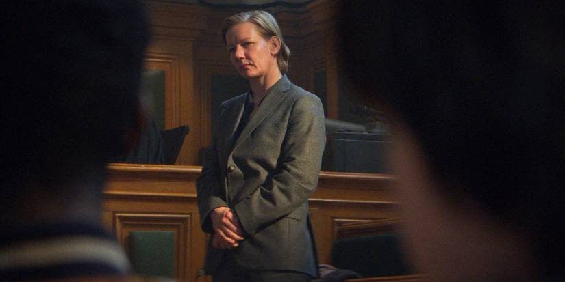 Sandra Hüller as Sandra Voyter, standing in court looking solemn in Anatomy of a Fall.