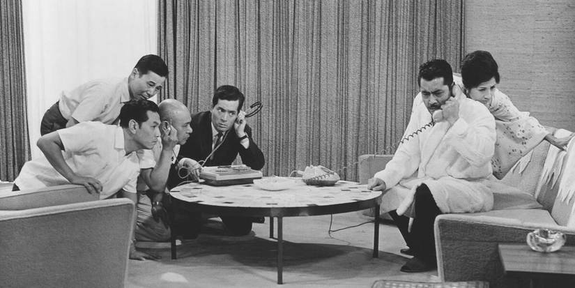 Toshiro Mifune as Kingo Gondo on a phone call, while his fellow cast members listen in, in 'High and Low'