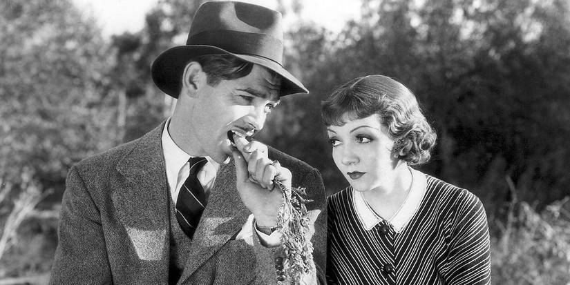 Clark Gable as ​​​​​​​Peter eats a carrot sitting next to Claudette Colbert as Ellie in It Happened One Night.