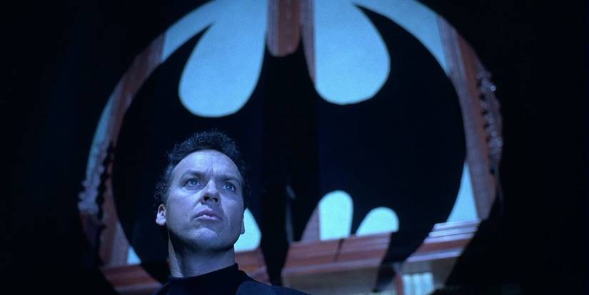 Michael Keaton as Bruce Wayne standing in front of the Bat signal in Batman Returns.