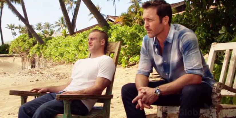two men sitting on a beach