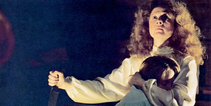 Piper Laurie as Margaret White, holding Carrie (Sissy Spacek) in one hand and a knife in the other in Carrie