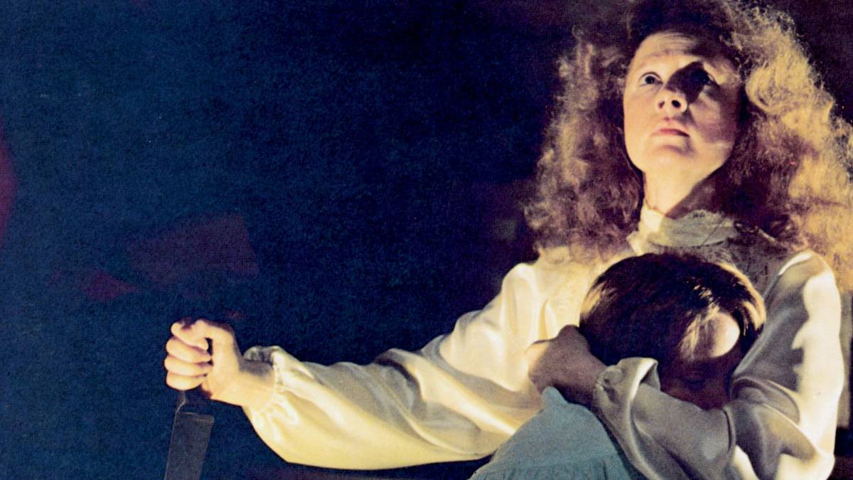 Piper Laurie as Margaret White, holding Carrie (Sissy Spacek) in one hand and a knife in the other in Carrie