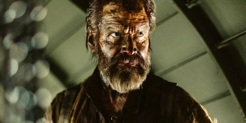 A man with blood on his face looking intently with a stern expression in Sisu