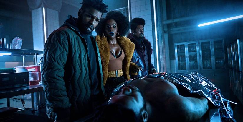  Fontaine (John Boyega), Yo-Yo (Teyonah Parris), Slick Rick (Jamie Foxx) looking at a body in a lab They Cloned Tyrone.