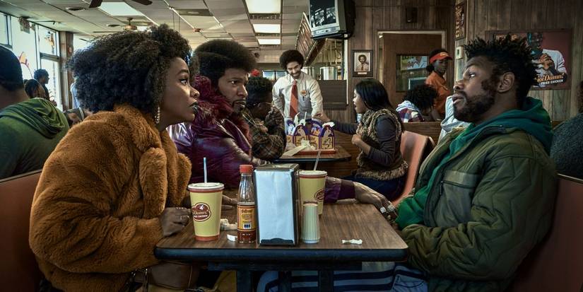 Fontaine (John Boyega), Yo-Yo (Teyonah Parris), Slick Rick (Jamie Foxx) sitting in a diner They Cloned Tyrone.