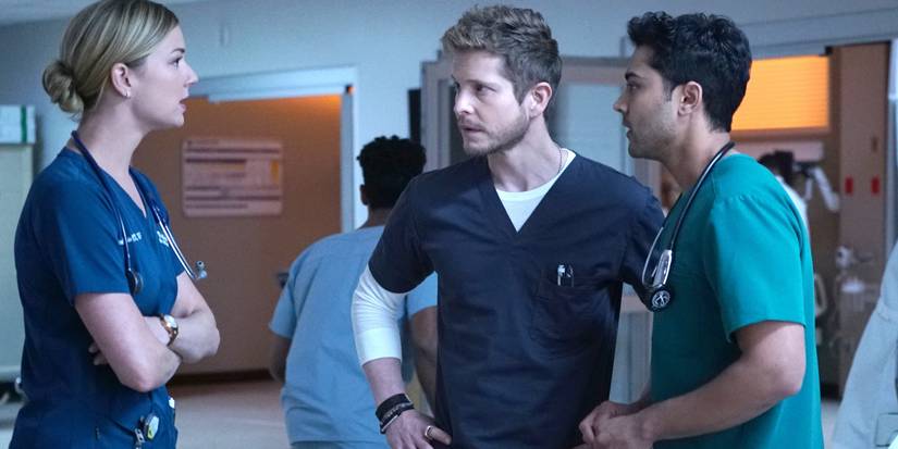 Matt Czuchry as Conrad Hawkins talking to Emily VanCamp as Nicolette Nevin and Manish Dayal as Devon Pravash in a hospital as doctors in The Resident