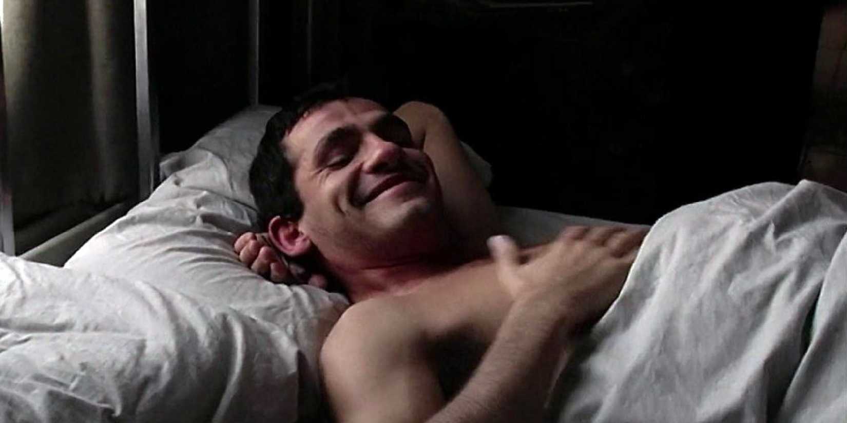 A shirtless man in bed in 9 Songs