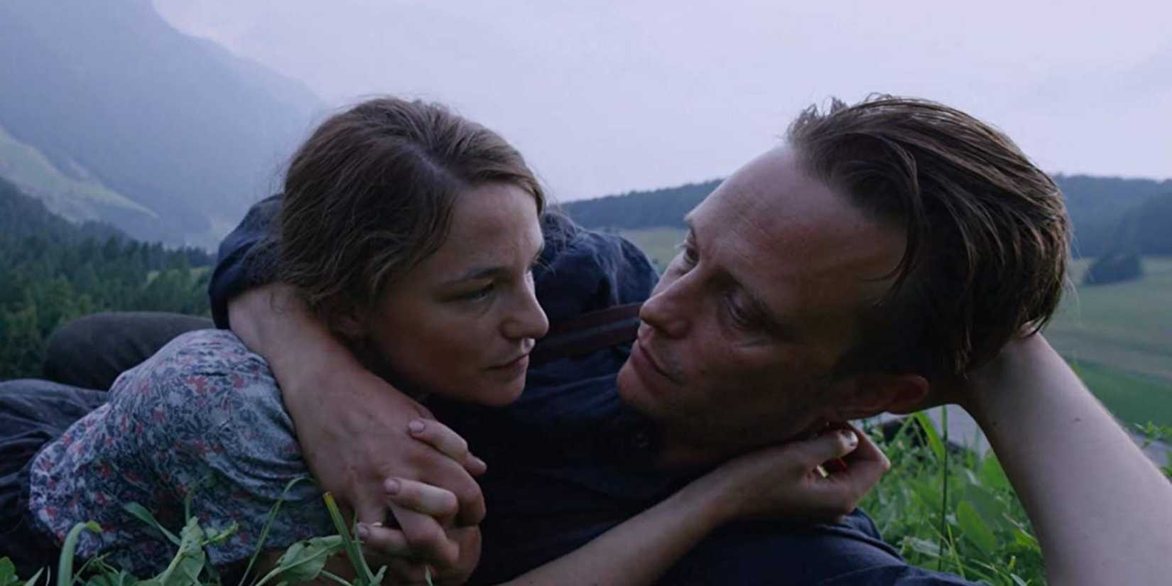 A Hidden Life' (2019) - sepasang kekasih berbaring bersama di rumput
