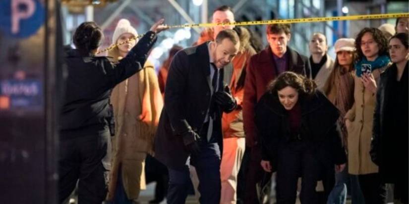 Man and woman walking under a crime scene tape.
