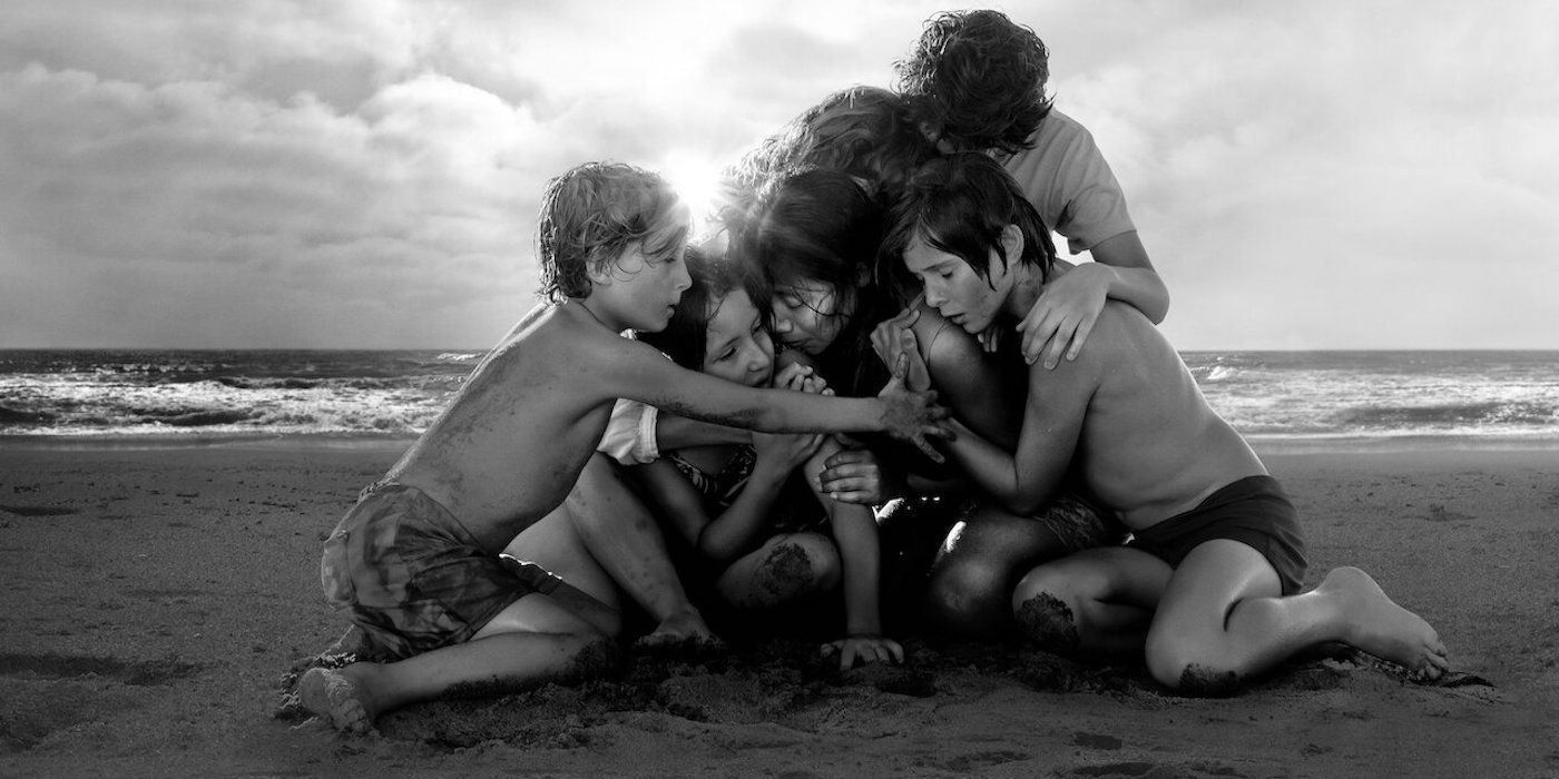 The cast of Roma, huddled on the beach