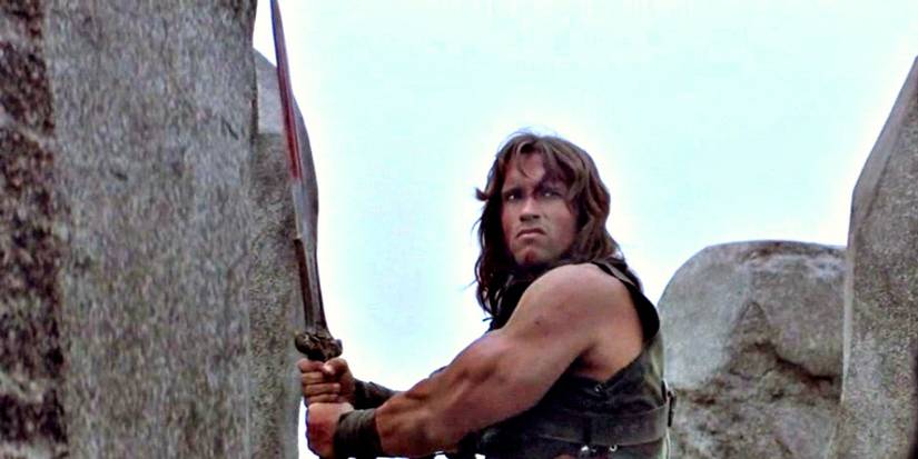 Conan the Barbarian (Arnold Schwarzenegger) holding a sword in Conan the Barbarian