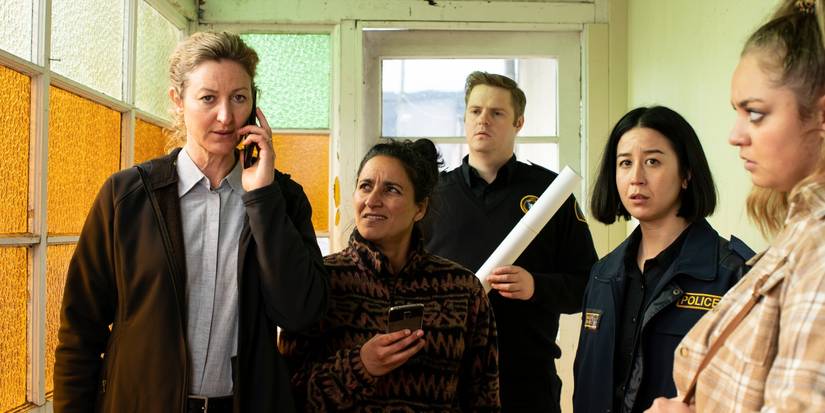 The cast of Deadloch stand in a corridor and look perplexed.