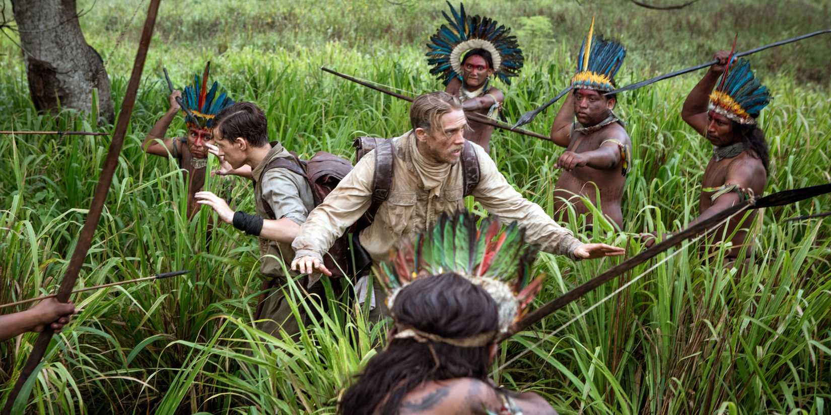 Charlie Hunnam and another person surrounded by people with spears in The Lost City of Z. 
