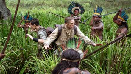 Charlie Hunnam y alguien más rodeado de gente con lanzas en La Ciudad Perdida de Z.