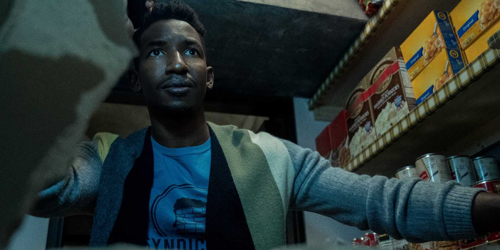 Mamoudou Athie in Archive 81 looking at a screen.