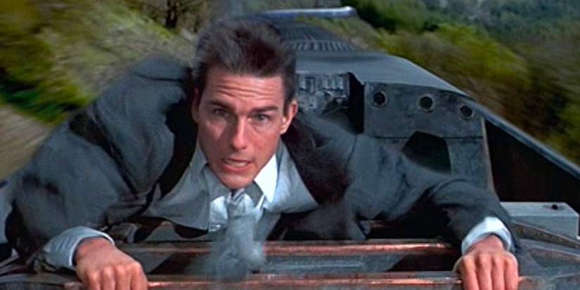 Ethan Hunt (Tom Cruise) climbs atop a speeding train.