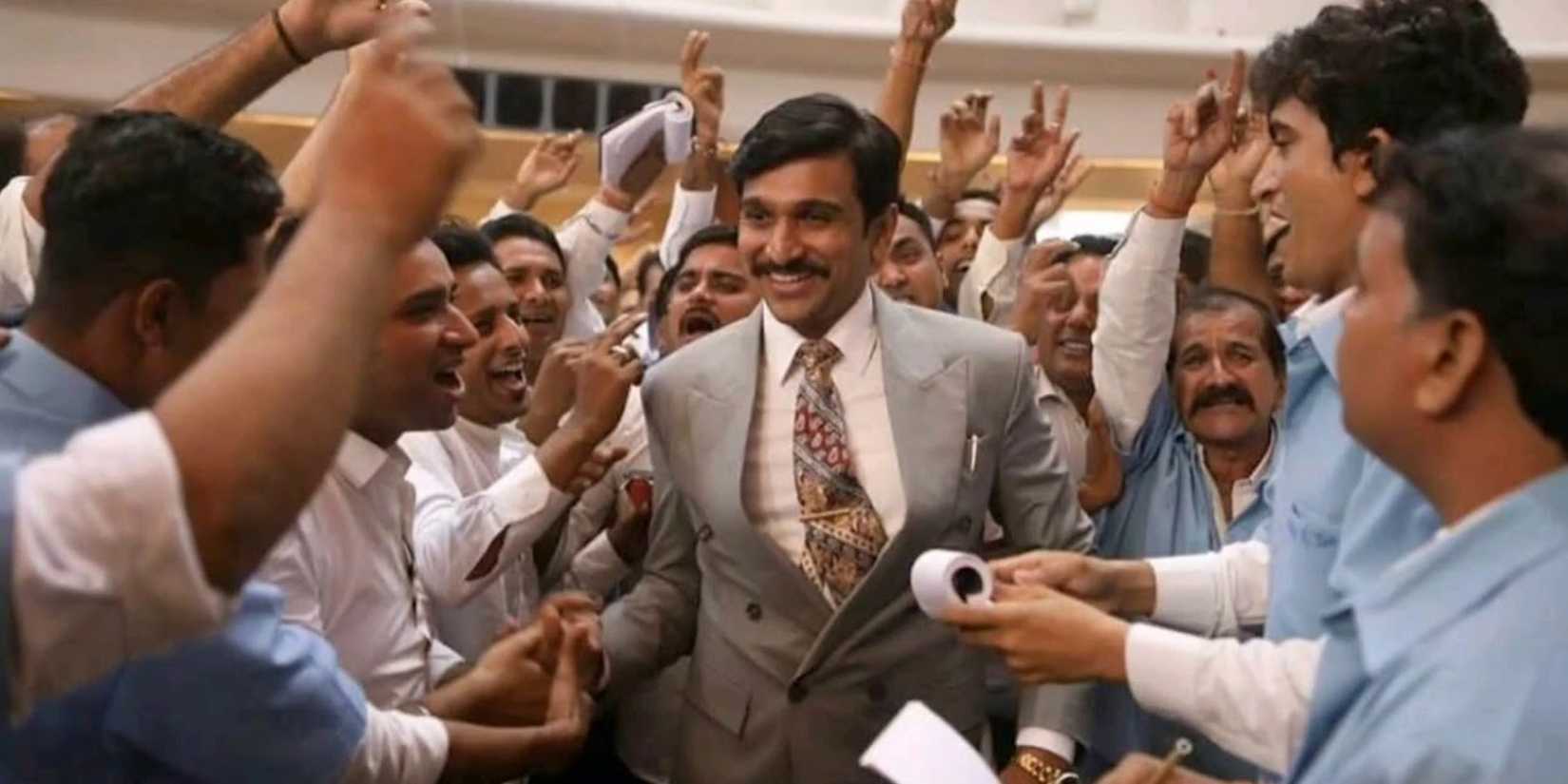 A man in a business suit walks through a cheering crowd in Scam 1992: The Harshad Mehta Story.