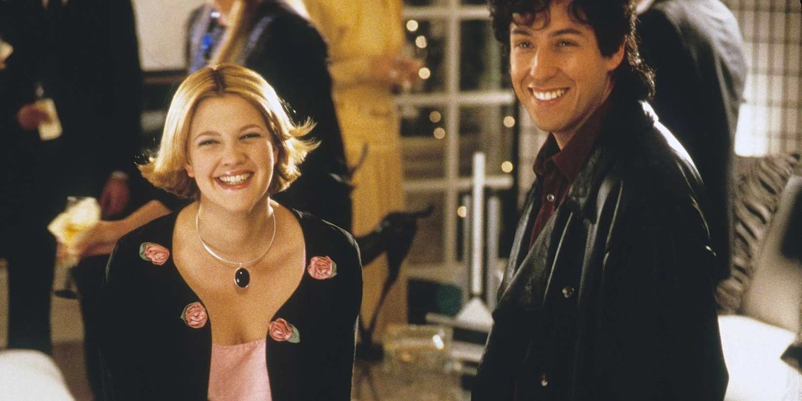 Julia (Drew Barrymore) and Robbie (Adam Sandler) smiling in 'The Wedding Singer'.