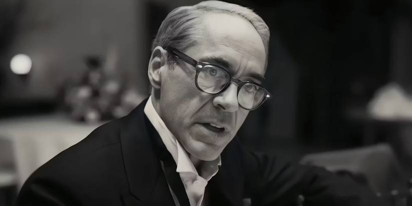 Lewis Strauss (Robert Downey Jr.), upset, sits at a table in a tux & argues about the nuclear bomb