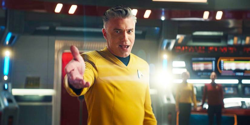 Anson Mount as Captain Pike in Star Trek Strange New Worlds extending his hand toward the camera in the musical episode.