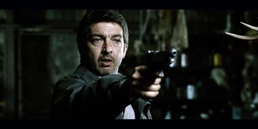 A man aiming his gun at someone off-camera in The Aura 2005