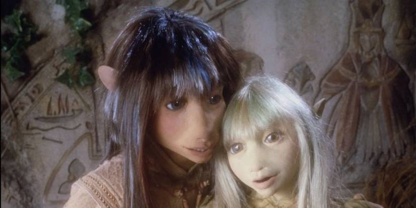 Two Gelfling characters embrace in The Dark Crystal.