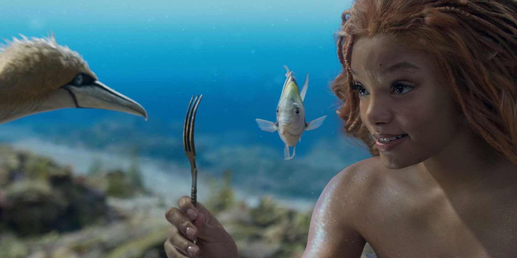 Halle Bailey as Ariel shows Scuttle and Flounder a fork that she found