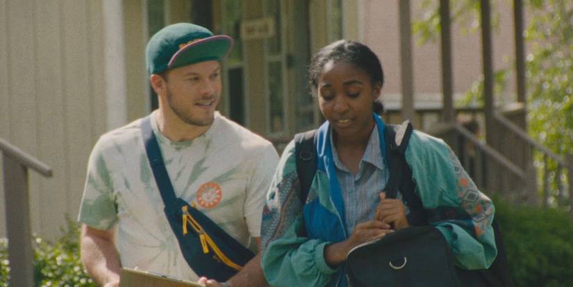 Jimmy Tatro as Troy and Ayo Edebiri as Janet walking down a street in Theater Camp