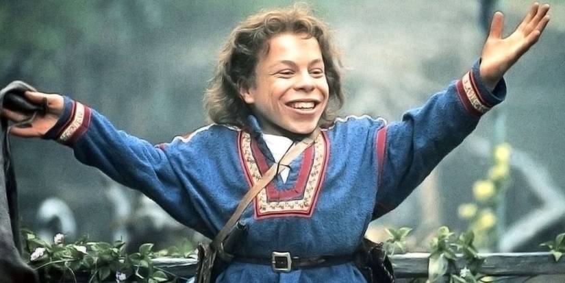 Warwick Davis as Willow spreading his arms in joy in Willow.