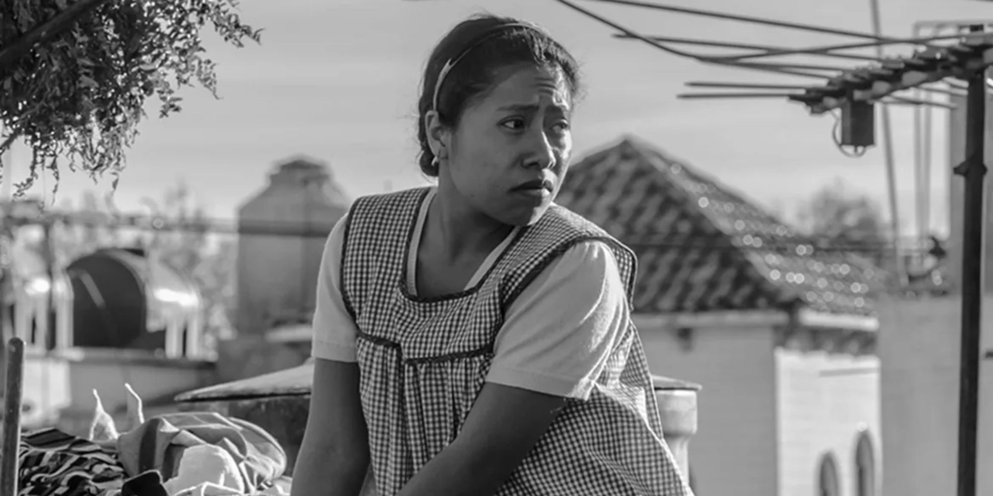 Yalitza Aparicio as Cleo turning around and looking to the distance in Roma