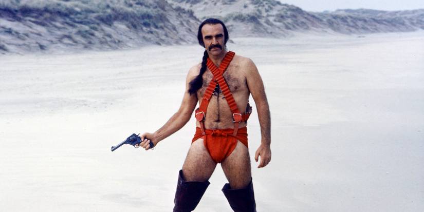 Zed holding a gun in a desert in Zardoz