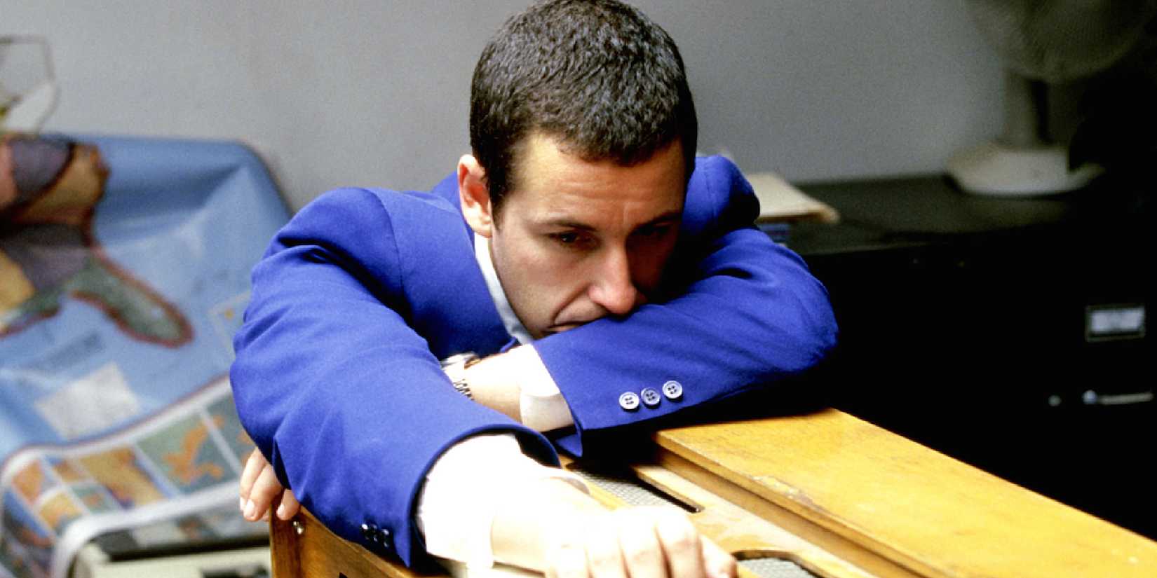 Adam Sandler dalam 'Punch Drunk Love' merosot di atas meja tampak sedih.