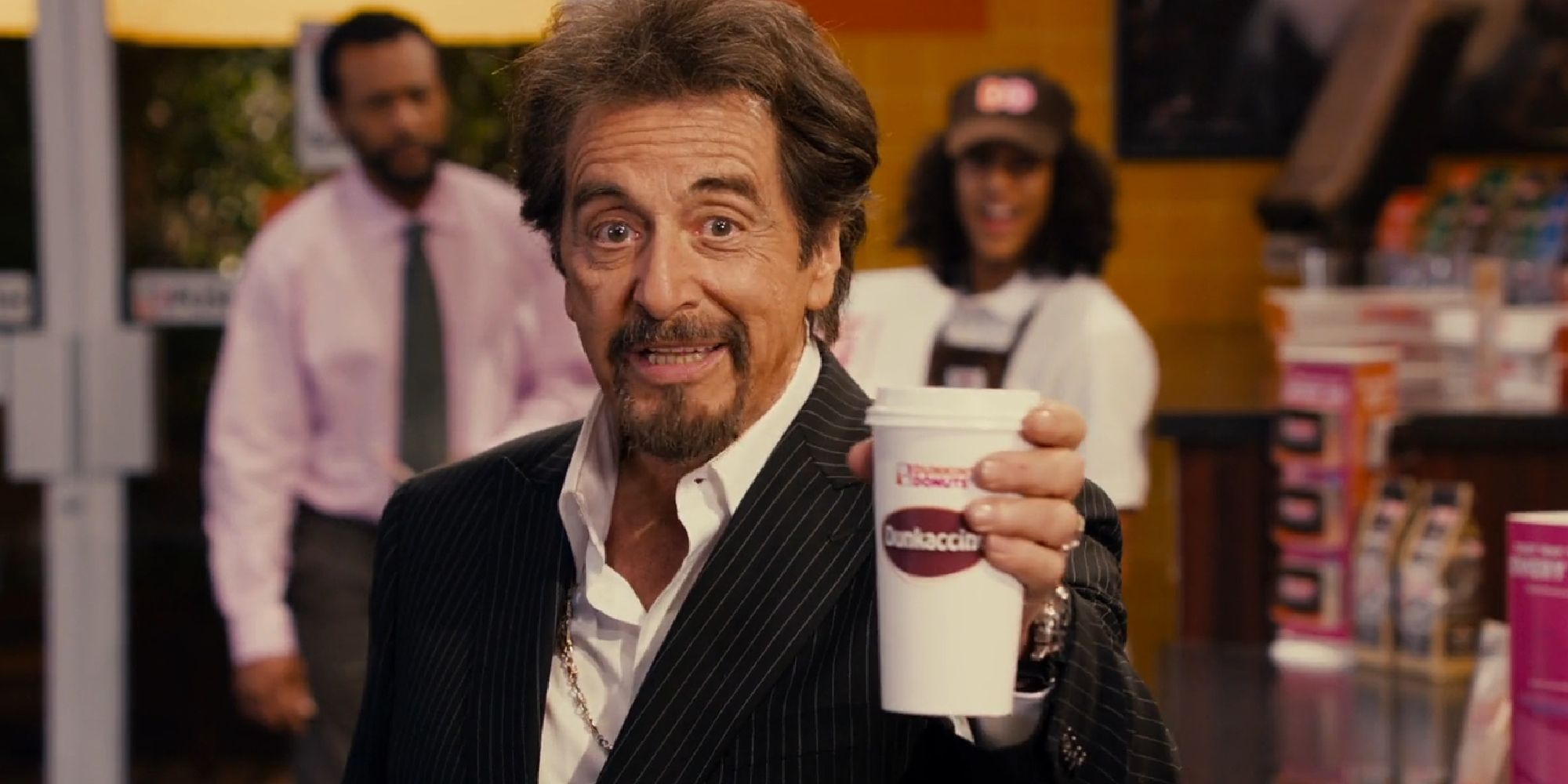 Al Pacino forces a smile while holding out a cup of coffee in 'Jack and Jill'.