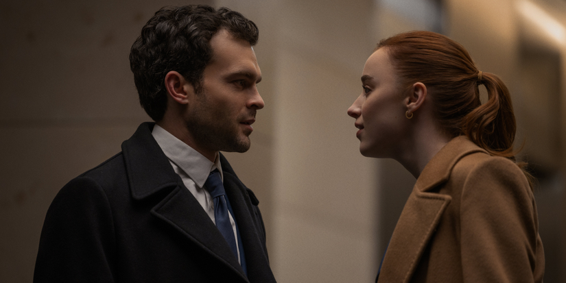 Luke (Alden Ehrenreich) and Emily (Phoebe Dynevor) talking in a hall in Fair Play 