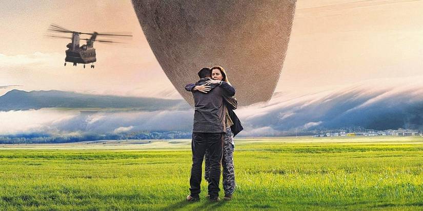 Amy Adams and Jeremy Renner hugging in a field, with a spaceship behind them in Arrival