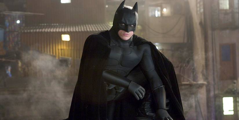 Christian Bale sebagai Batman berjongkok di Batman Begins