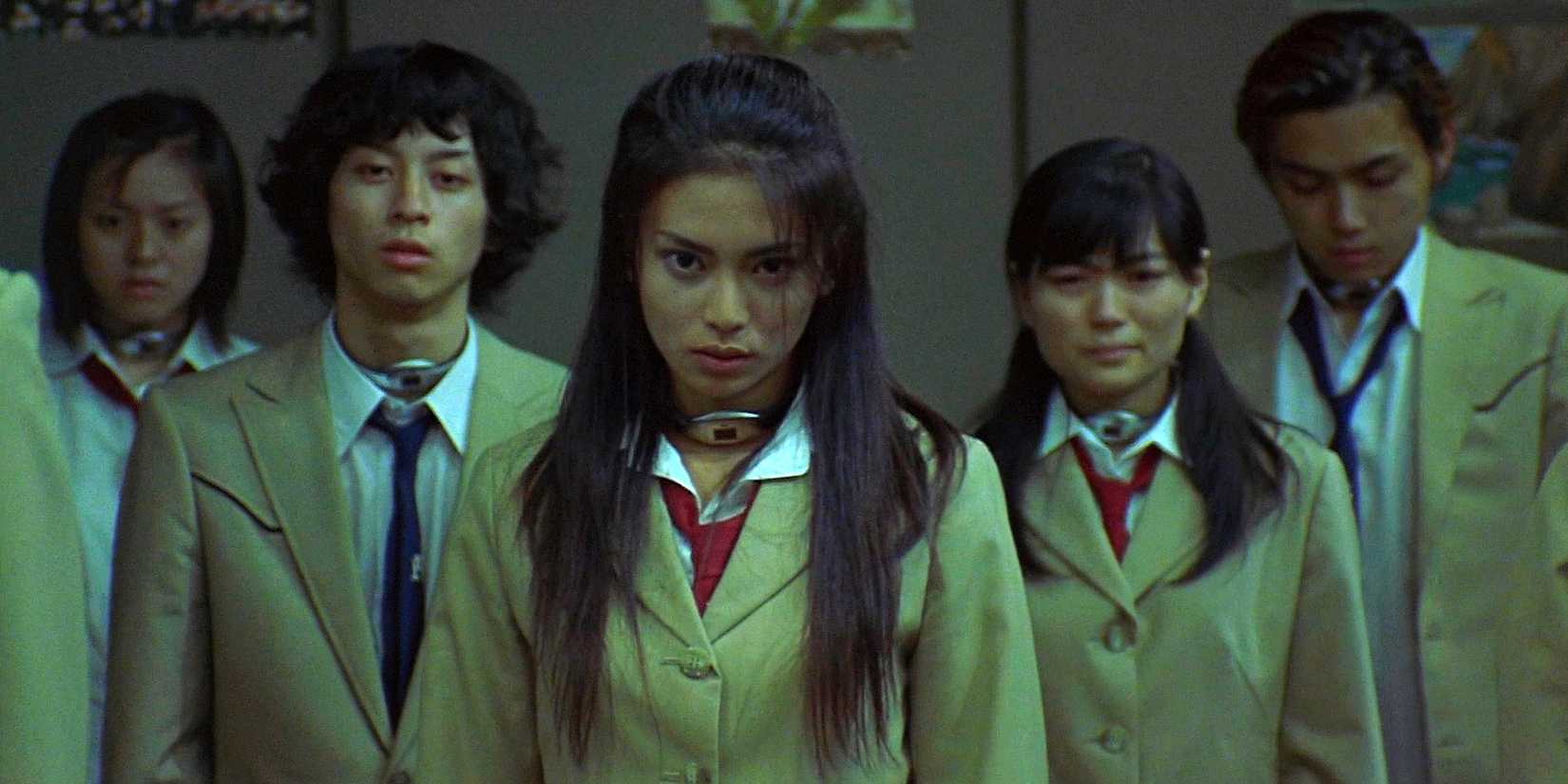 Five high school students stand in a line and look viciously at the camera in Battle Royale.