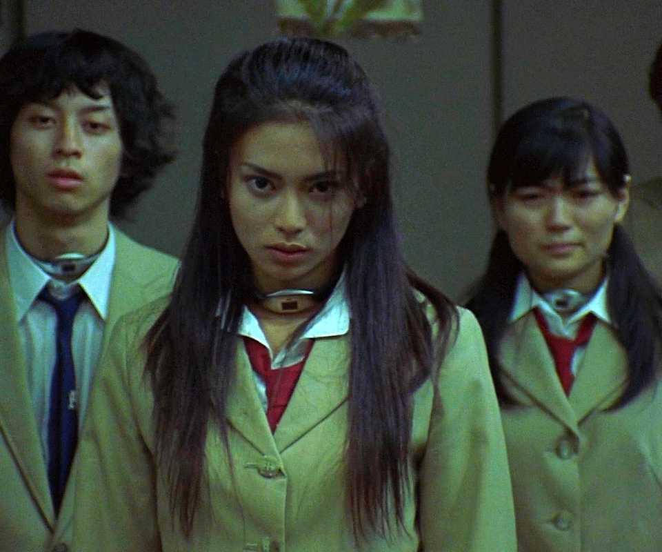 Five high school students stand in a line and look viciously at the camera in Battle Royale.