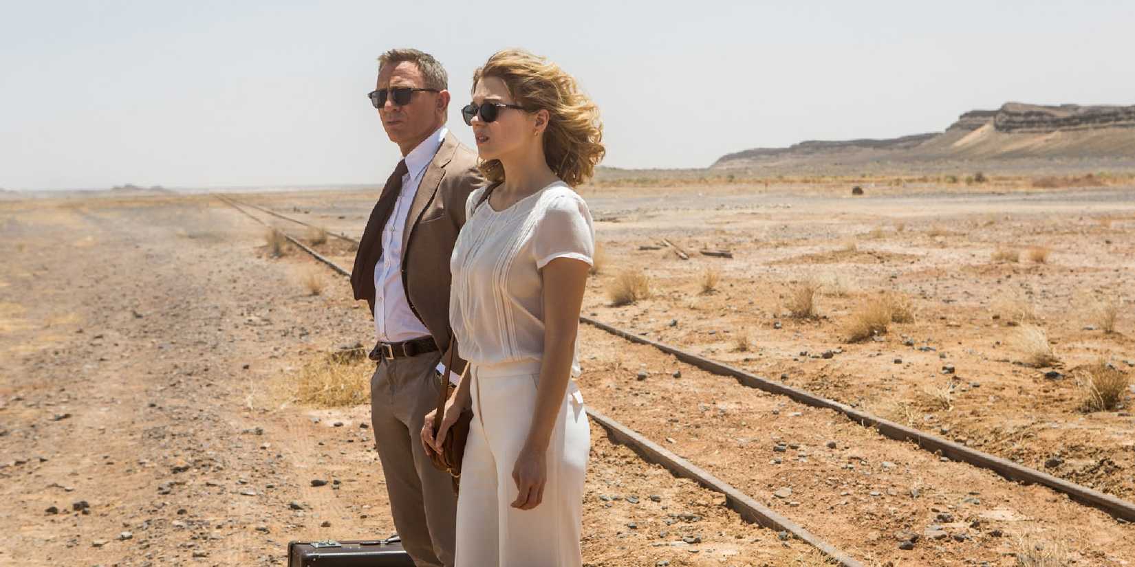 Daniel Craig (James Bond) and Lea Seydoux (Madeleine Swann) standing by train tracks in 'Spectre'.