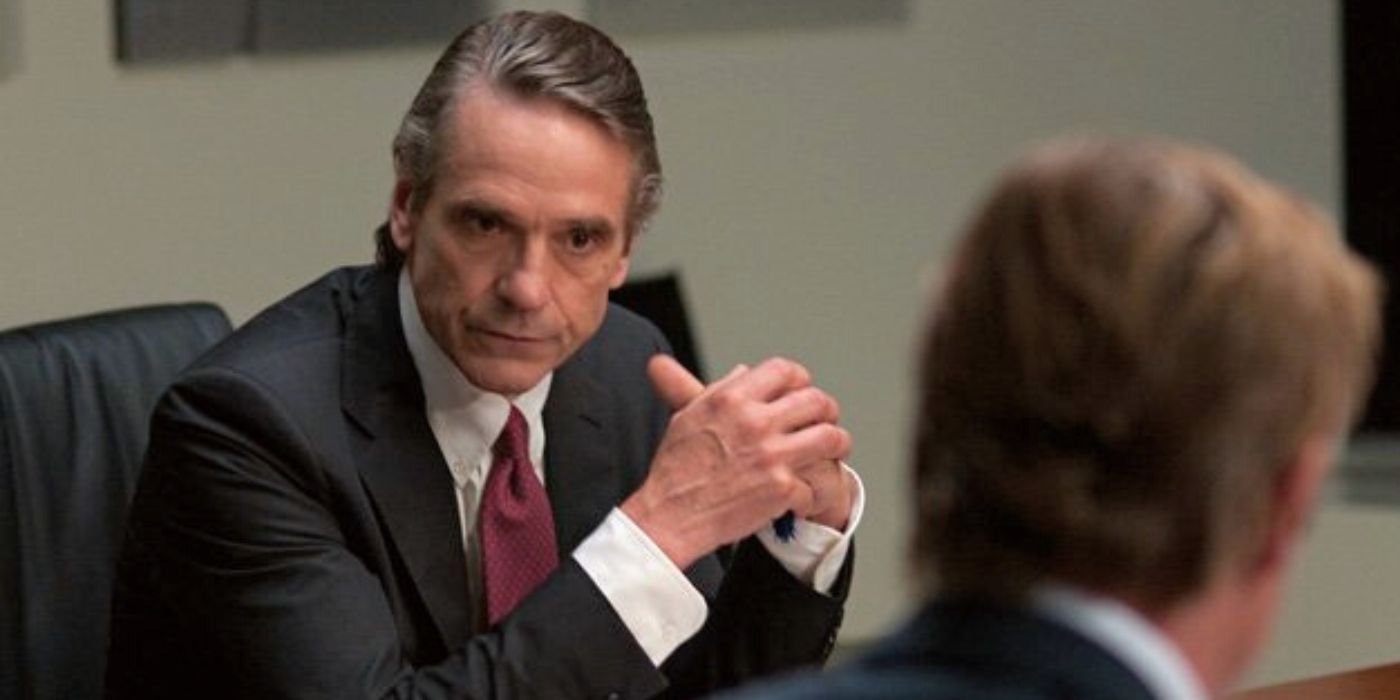 Jeremy Irons sitting at table with his hands folded in Margin Call (2011)