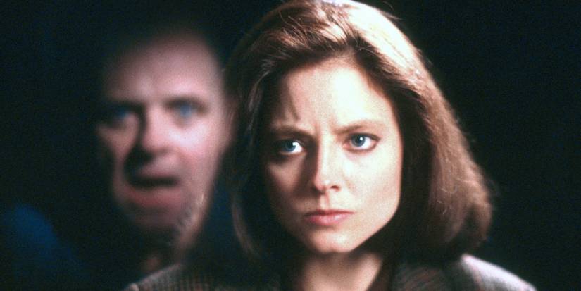 Clarice looking intently with Hannibal Lecter's reflection beside her in The Silence of the Lambs