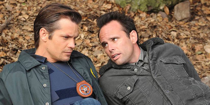 Timothy Olyphant's Raylan Givens and Walton Goggins' Boyd Crowder in Justified on a leafy ground.